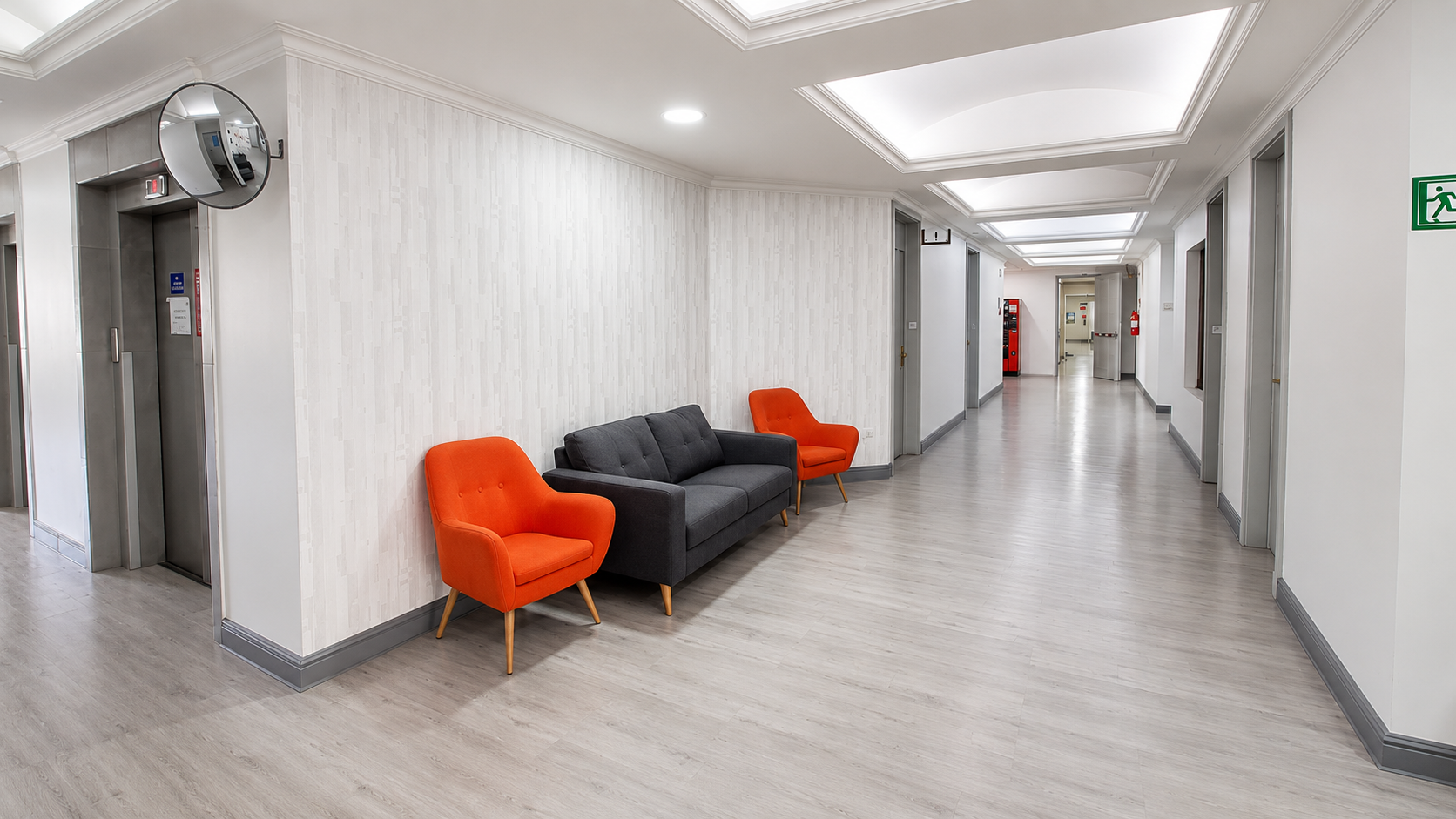 Hall con mobiliario naranja en Clínica Los Coihues